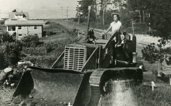 Hogans Road - Photo By: <a href="https://kura.aucklandlibraries.govt.nz/digital/collection/photos/id/31014">Judy Pyle on tractor at 60 Hogans Road, Glenfield, 1960. Photo by Royston Pyle. Auckland Libraries Heritage Collections T1118.</a>